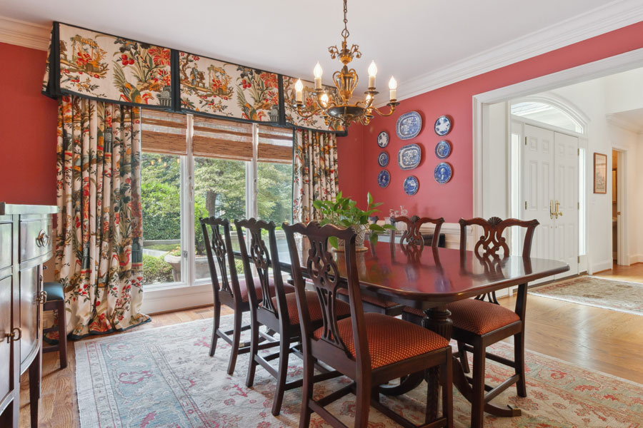Cozy backyard patio with a wooden pergola, warm string lights, outdoor seating, and a grill, ideal for evening relaxation and entertaining in a suburban Atlanta home.