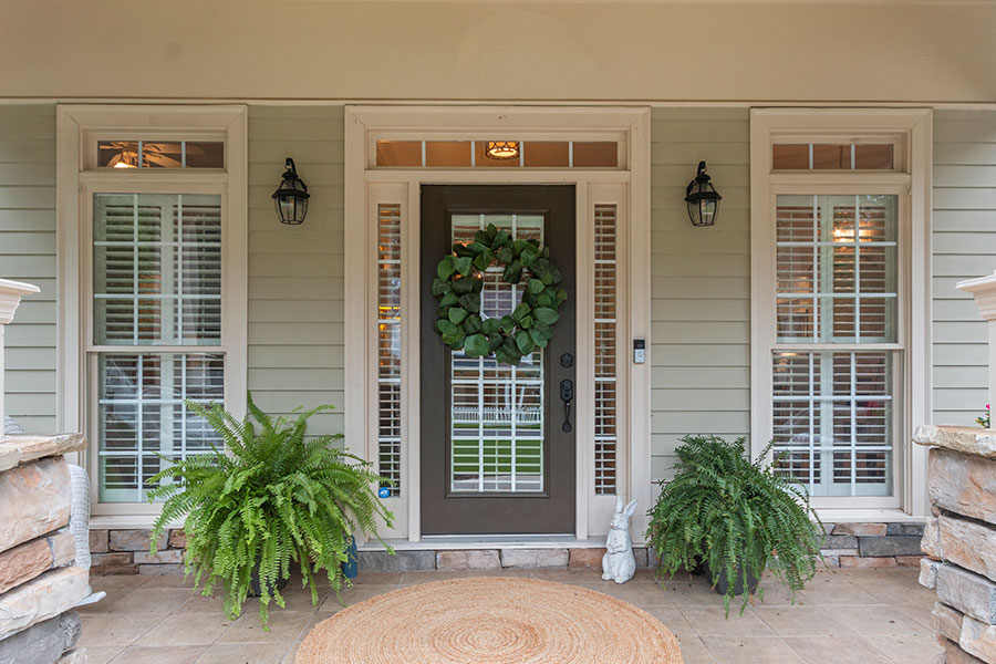 Modern living room with vaulted ceilings, neutral gray walls, wood flooring, and cozy decor, featuring a wall-mounted TV, fireplace, and natural lighting, perfect for open-concept home buyers in Acworth, Georgia.